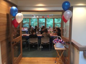 Group gathered around decorated table with balloons