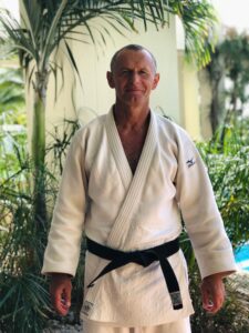 Man in white judo gi with black belt